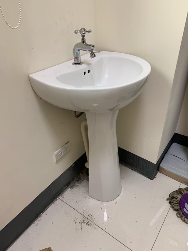 1) 這張照片顯示一個白色的洗手台，帶有單個水槽和一個單孔水龍頭