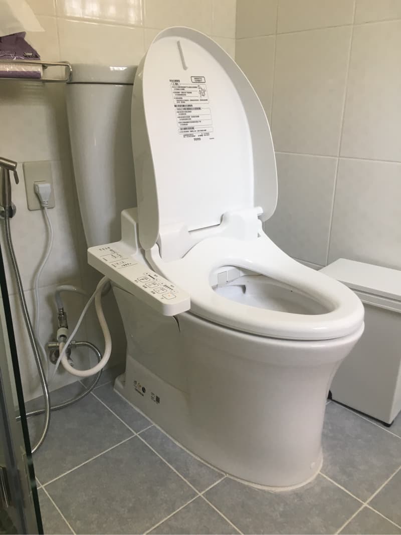 這張照片是一個TOTO牌的智慧馬桶，它有自動沖水、溫水洗淨和烘乾等功能，看起來很現代化。