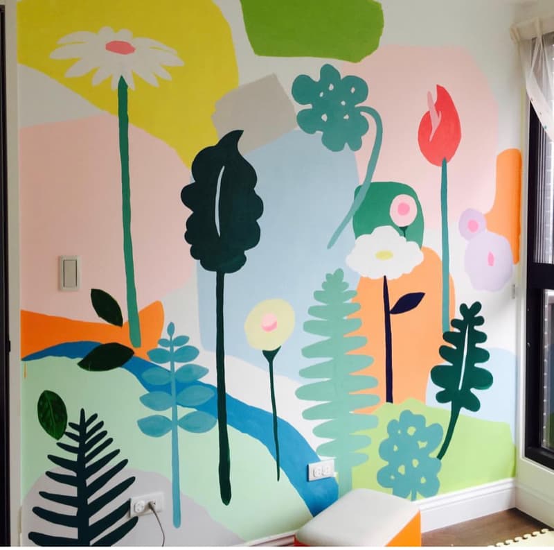 這張「牆壁」的照片是彩色的，上面畫著各式各樣的植物，有花朵、樹葉和樹木，背景是柔和的粉色、藍色和綠色。