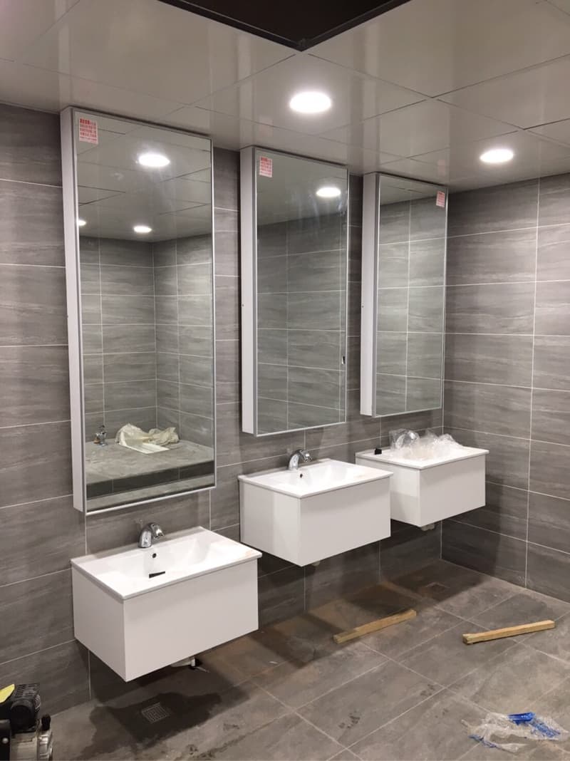 這張照片是一個浴室，最重要的是三面鏡子，兩邊各有兩個洗手台，中間有一個長方形的鏡子。