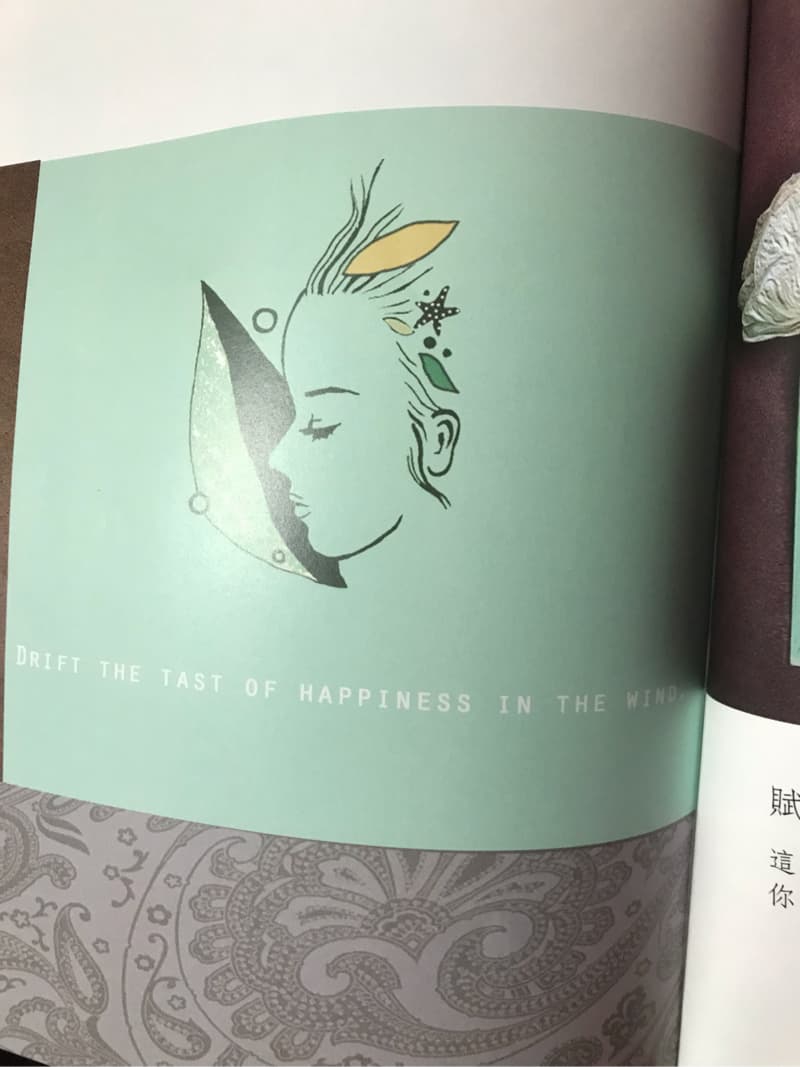 這張「漂浮在風中的幸福滋味」的照片是一個女性的頭像，她頭髮上有一些裝飾，例如貝殼、星星和樹葉。