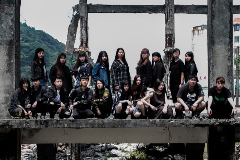 這張「一群年輕人站在破舊建築物上」的照片是，他們穿著休閒服裝，看起來像是朋友，正在一起拍照。