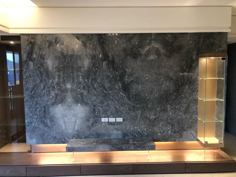 這張照片是一個現代化的客廳，牆壁上有一個大理石牆面，上面裝飾著燈光。牆面的紋路非常漂亮，讓人感覺非常高檔。