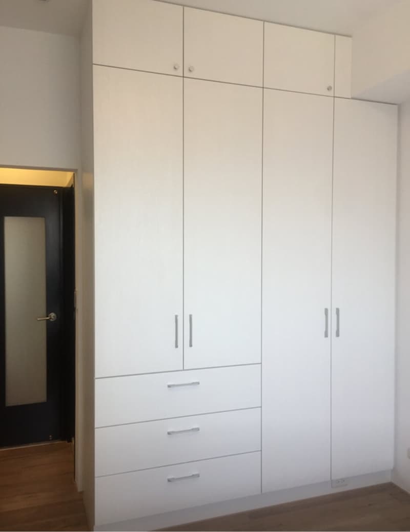 這張照片是一個大型白色衣櫃，有三個門和三個抽屜，設計簡潔，看起來非常實用。