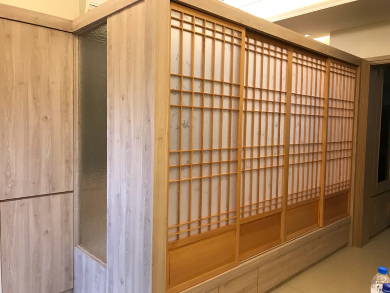 這張照片是木質的推拉門，門上是格柵設計，並且有木質的橫條設計，看起來非常簡約和現代。