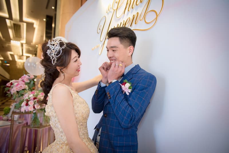 這張「婚禮」的照片是一對新人互相看著彼此。新娘戴著皇冠,穿著白色的婚紗,新郎穿著藍色的西裝,看起來很幸福。