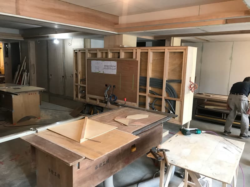 這張照片是一個正在施工的房間，最重要的部分是房間裡的木工工作台，工作台上放著一些木板和工具，正在進行木工加工。