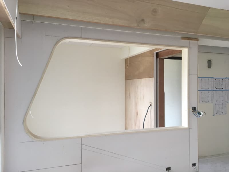 這張照片是一個正在裝修的房間，最顯眼的特色是牆上一個新做好的弧形窗戶。窗戶的設計簡潔優雅，線條流暢，為房間增添了一份獨特的韻味。