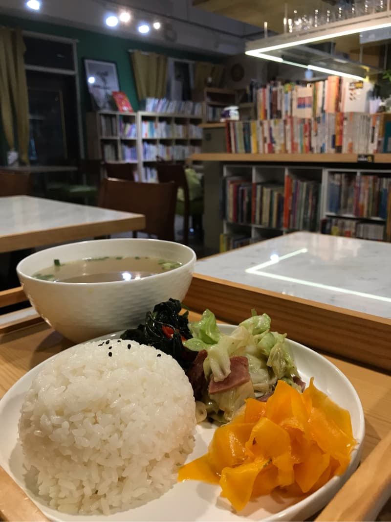 這張照片是一盤美味的午餐，包含白飯、青菜、醃製黃蘿蔔和一碗湯。