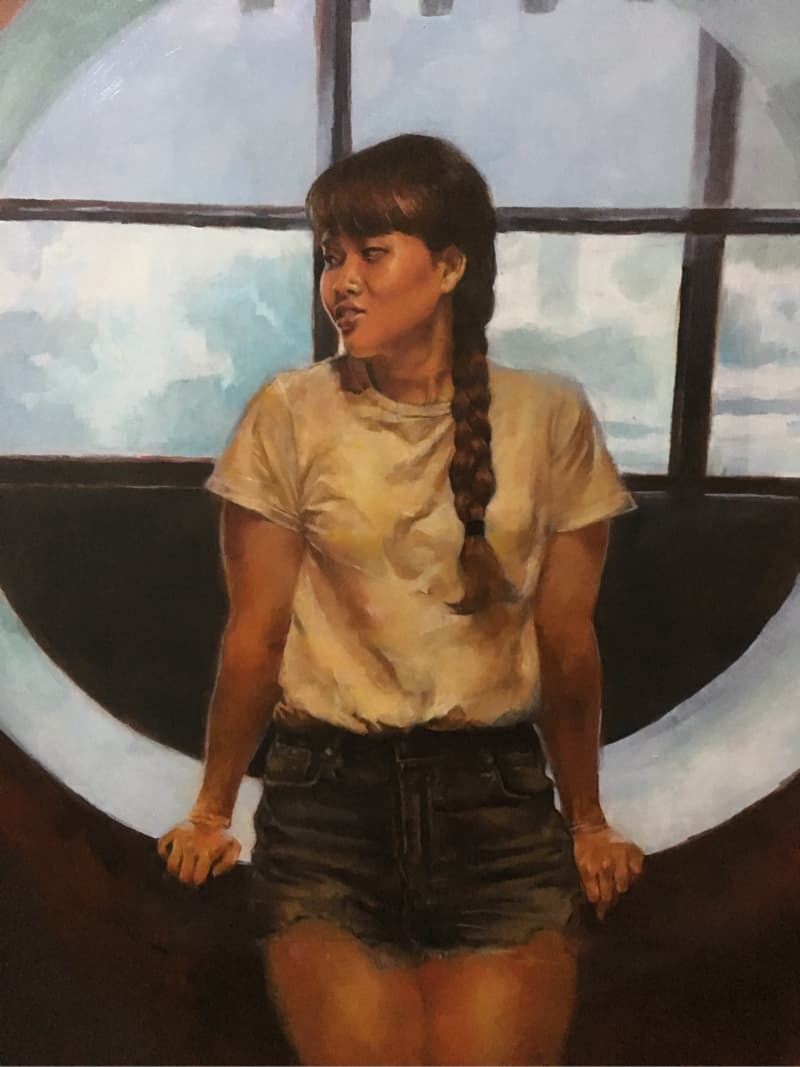 這張照片是一個年輕女子站在窗戶邊，她的頭髮編織成辮子，她穿著一件白色T恤和牛仔短褲，正在注視著窗外。