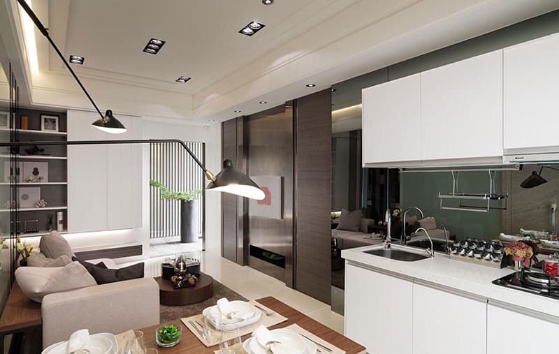 這張照片是一個現代化的廚房，有著白色櫃子、黑色水槽和石英檯面，以及一個黑色的烤箱。