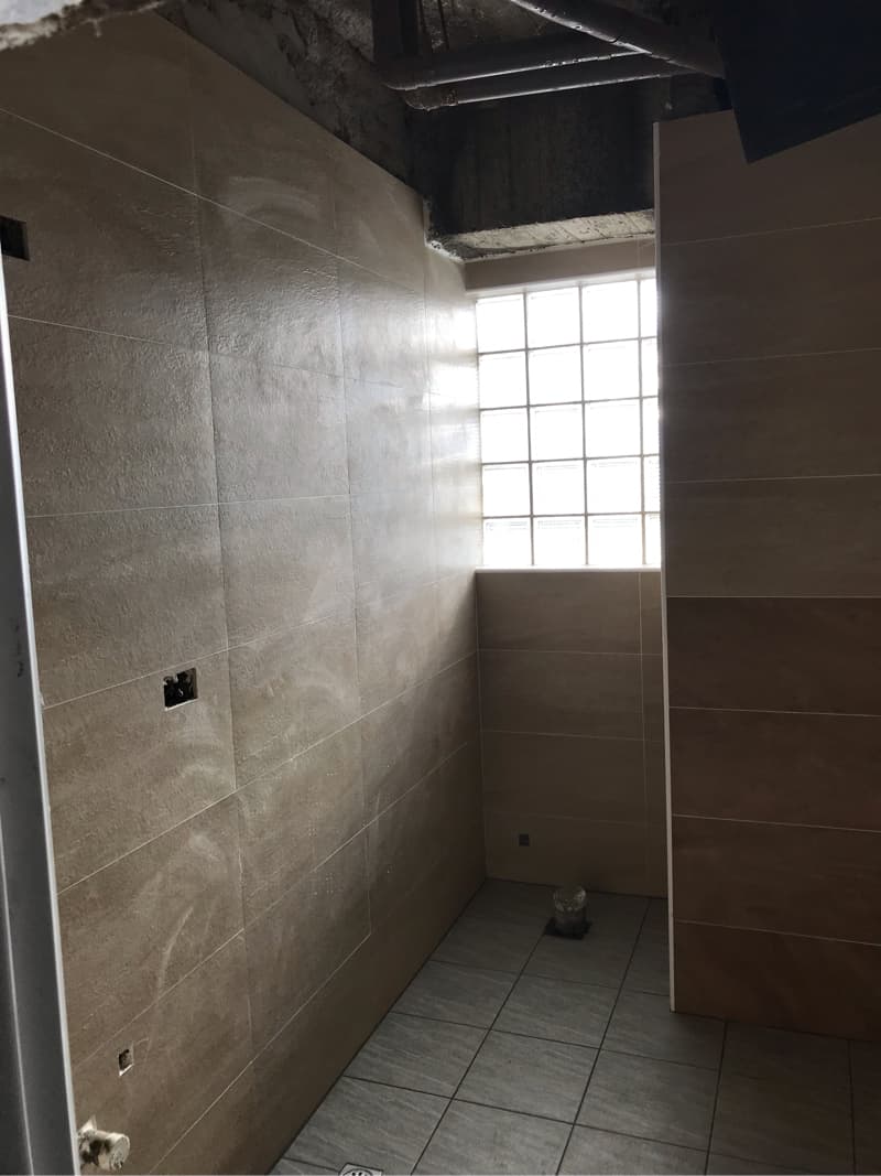 1) 照片顯示一個浴室的角落，其中包含部分牆壁和地板