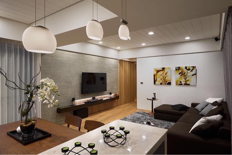 這張「現代化客廳」的照片是一個明亮的空間，有灰色沙發、木地板和白色天花板。客廳裡有電視、兩幅藝術品和一個時尚的咖啡桌。