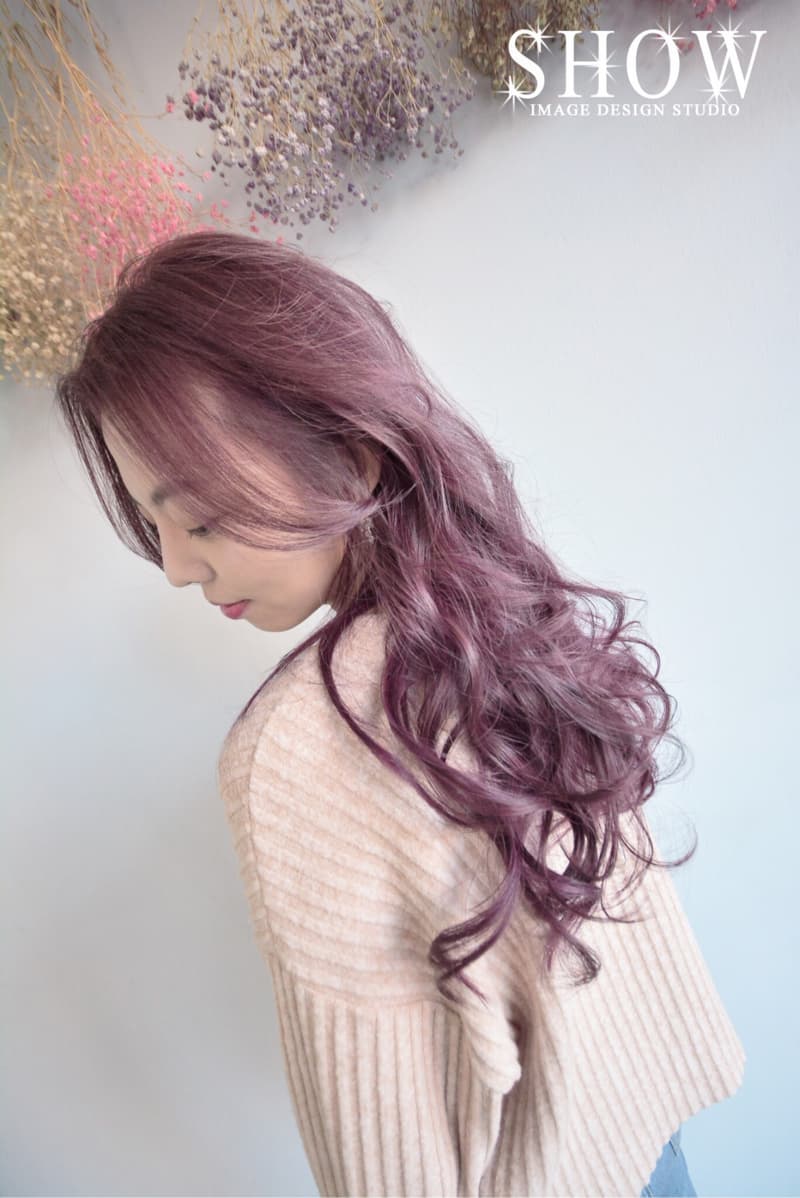 這張「女生髮型」的照片是一個女生留著一頭浪漫的捲髮，髮色是淡淡的紫色。