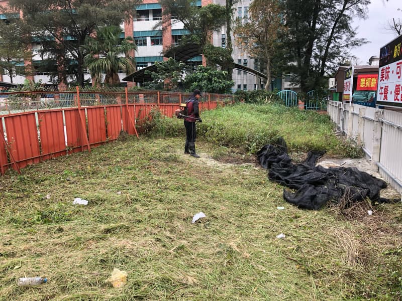 這張照片是一個人在用割草機修剪草坪。