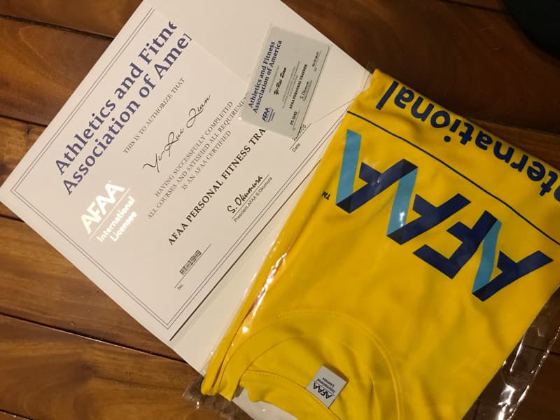 這張照片是一個美國運動與體能協會的證書和一件印有協會標誌的黃色 T 恤。