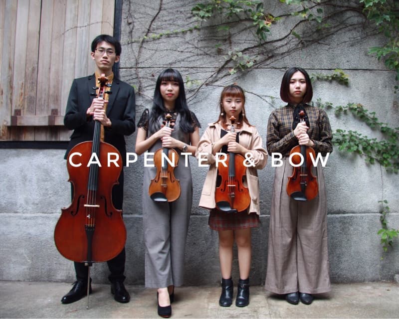 這張照片是四位年輕人站在牆壁前，他們每個人都拿著一把小提琴，並且上面寫著「CARPENTER & BOW」。