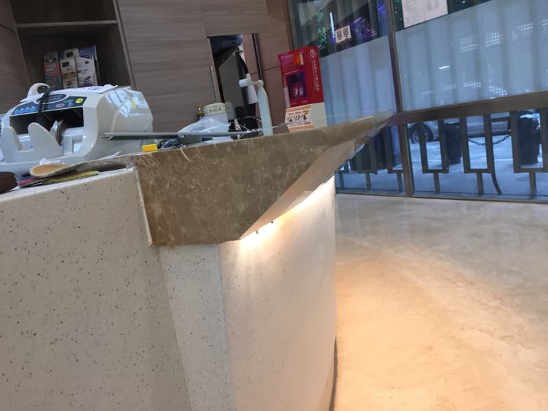 這張照片是一張石材檯面，檯面是深棕色的大理石，表面有光澤，檯面側面有 LED 燈，燈光照射在檯面上，讓檯面看起來更加明亮。