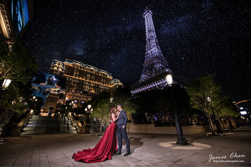 這張照片是一對情侶在巴黎鐵塔的複製建築前合影。他們穿著正式的禮服，看起來非常幸福。背景是滿天繁星，景色非常浪漫。