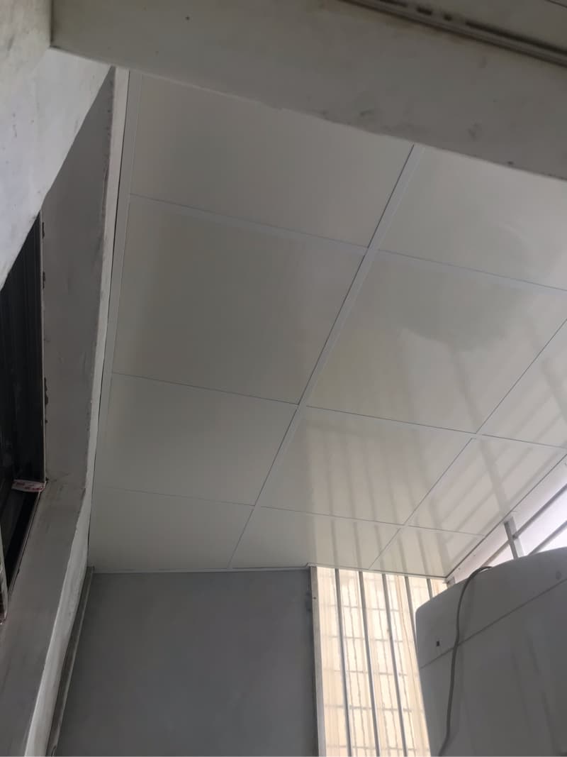 這張照片是一個房間的天花板，天花板是白色且由多個方形的板子組成，看起來很乾淨。