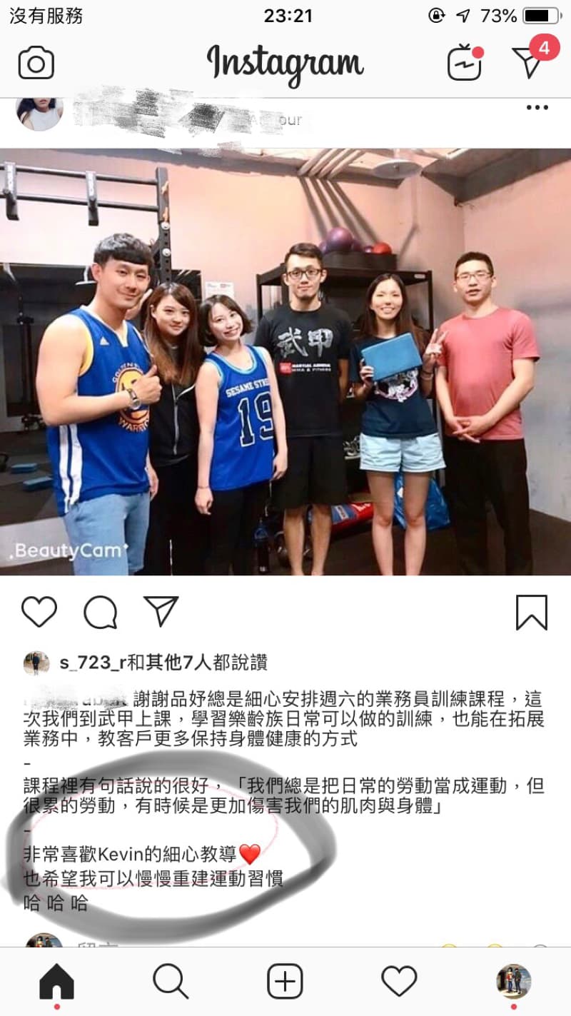 這張照片是  一個健身房的照片，照片中一群人圍在一起，其中一個人指著一個愛心，表示對健身教練的感謝。