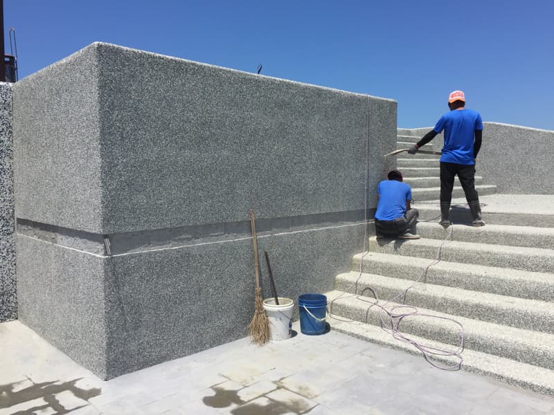 1) 照片顯示兩位身穿藍色上衣的工人正在建築工地上工作