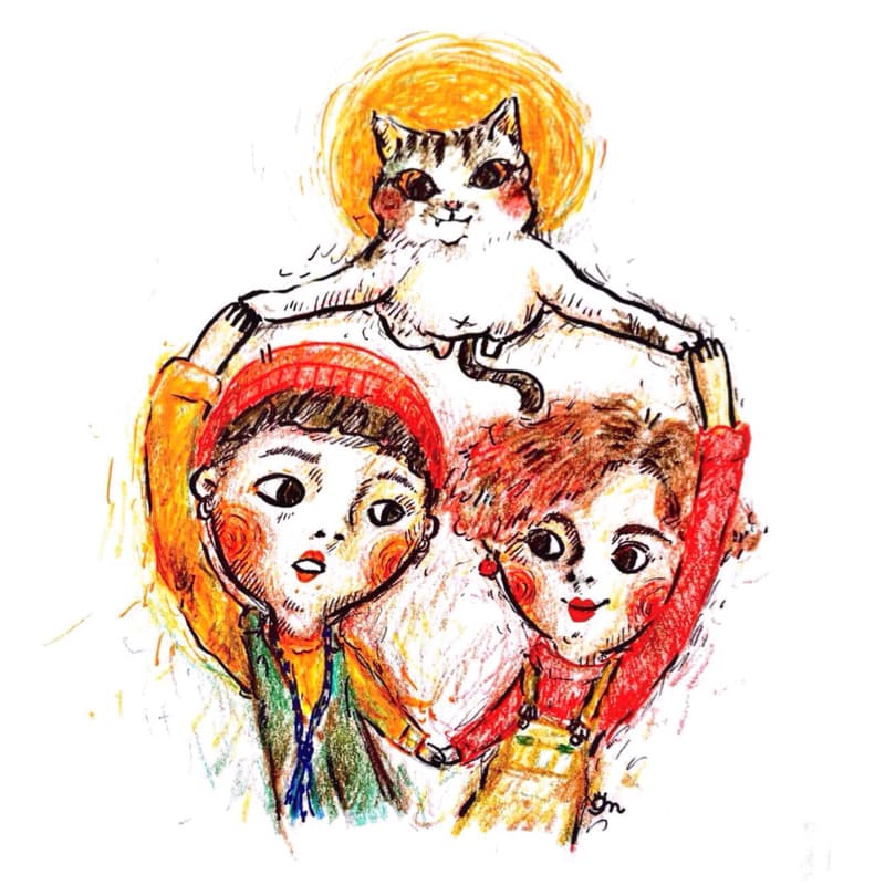 這張照片是兩個孩子和一隻貓咪，他們一起玩耍，圍成一個圈。貓咪在中間，孩子們在外面，他們都露出快樂的笑容。