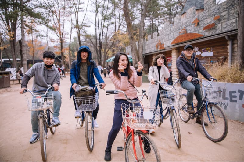 這張「五位朋友在公園裡騎自行車」的照片是,他們在秋天的樹林裡,騎著自行車,開心聊天,享受美好時光。