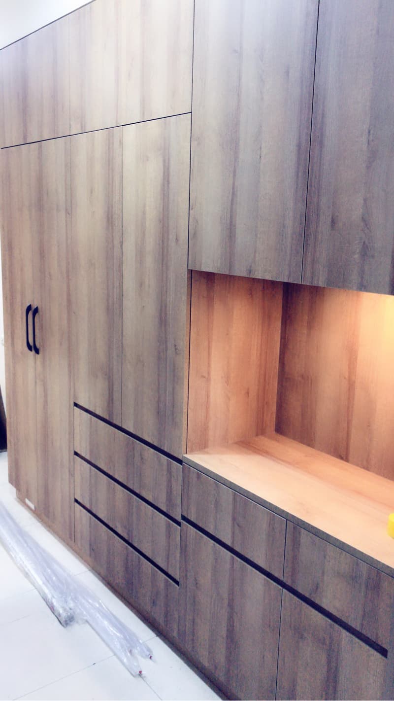 這張照片是一個木製的櫥櫃，它有許多抽屜和門，還有一個帶有燈光的開放式隔層。