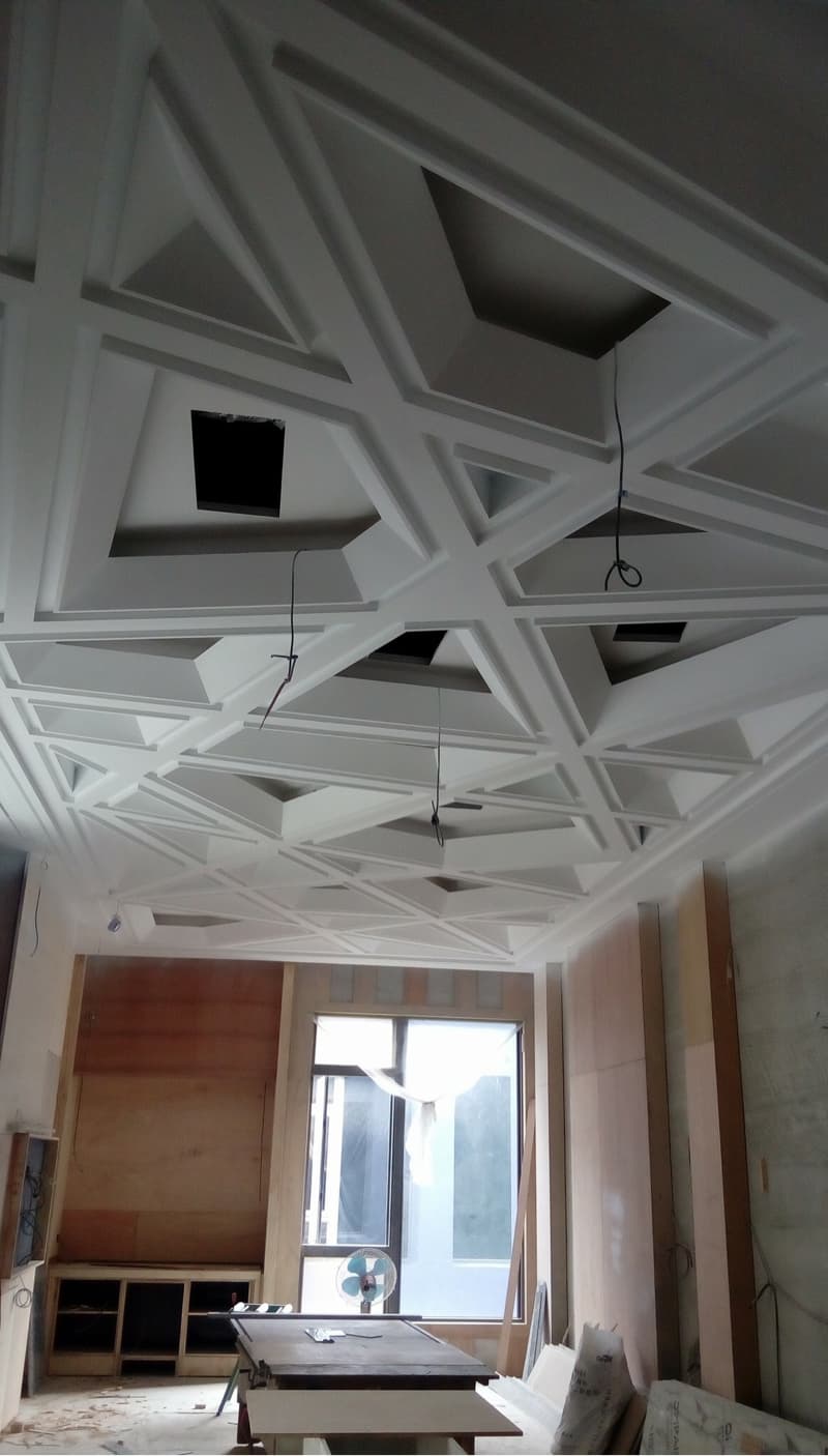 這張照片是一個正在裝修的房間，最引人注目的地方是房間的天花板，上面設計了精緻的三角形圖案，為這個空間增添了獨特的視覺效果。
