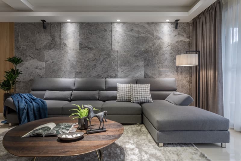 這張客廳的照片是一張灰色沙發和一個木質咖啡桌，沙發旁邊有一個落地燈。