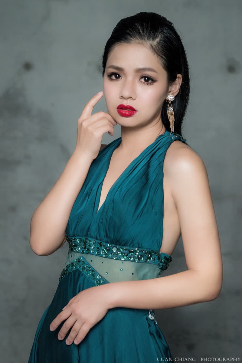 這張「美女穿著翠綠色禮服」的照片是一個優雅的肖像，她身穿一件亮麗的禮服，並帶著一對閃亮耳環。