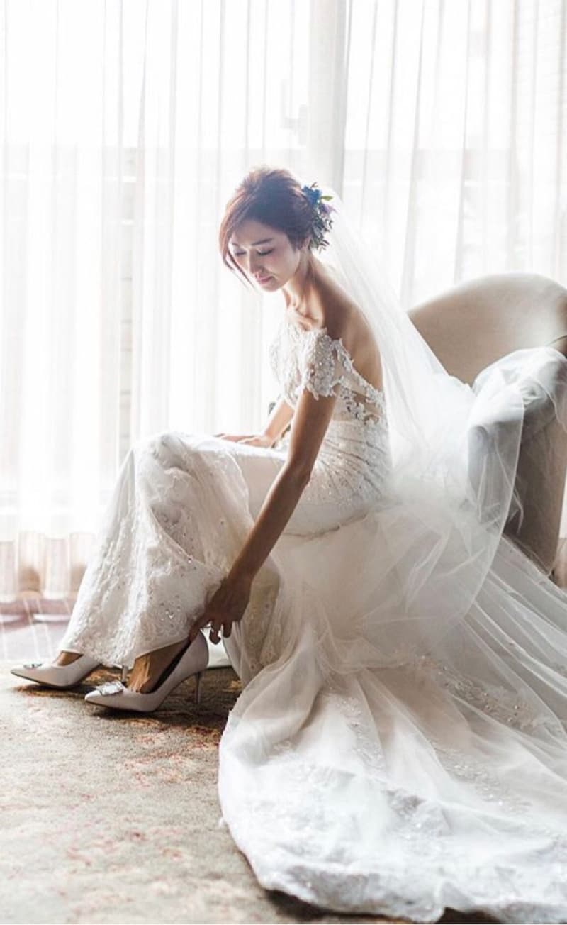 這張「婚紗照」的照片是一名穿著白色婚紗的新娘，她正坐在椅子上，準備穿鞋。
