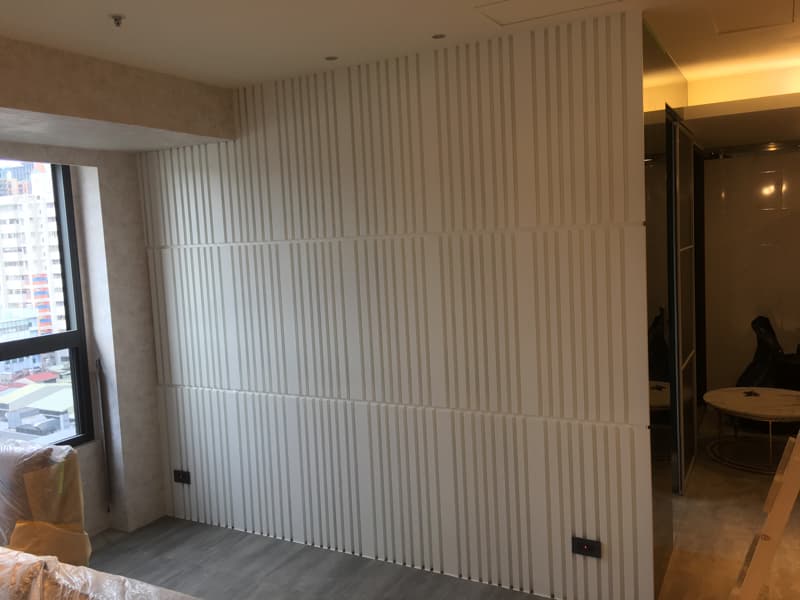 這張照片是一堵白色條紋牆，由許多垂直的條紋組成，看起來像是瓷磚，但表面卻非常光滑，呈現出簡約的現代感。