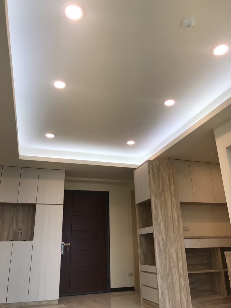 這張照片是一間裝修精美的現代化客廳，天花板安裝了多盞嵌燈，營造出明亮的空間感。