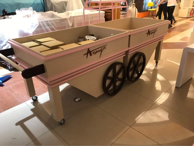 這張照片是一個木製的手推車，上面有粉紅色的邊緣，上面寫著「Amy's」。手推車上有兩個輪子，看起來很堅固。