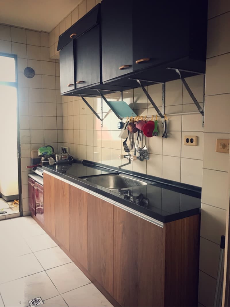 這張照片是一個廚房，最重要的是木頭材質的流理台，上面放著黑色的流理台面和水槽。