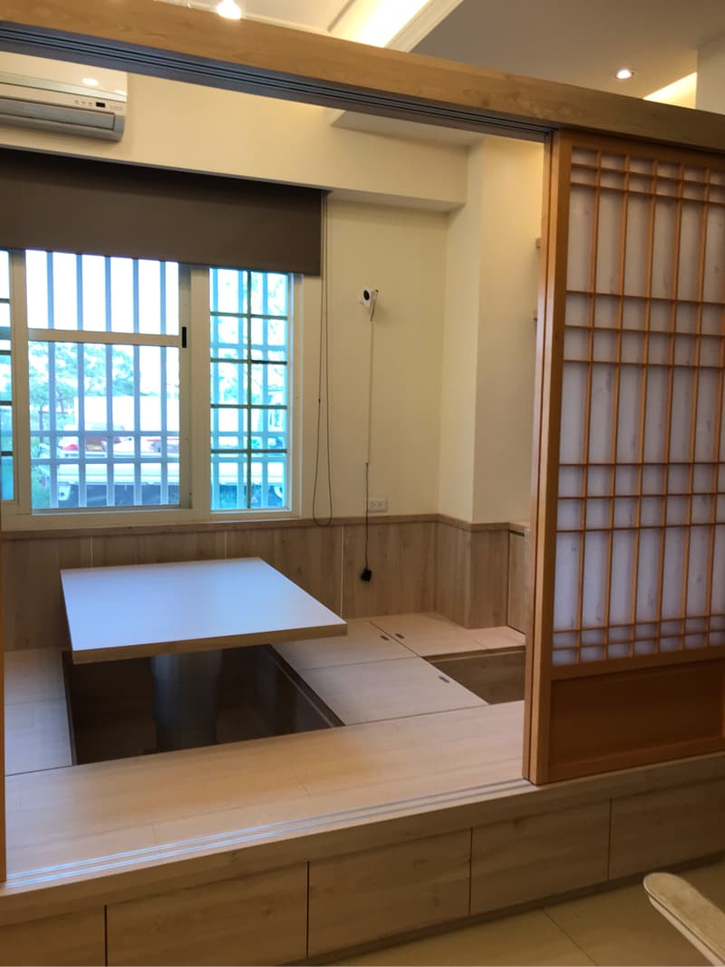 這張照片是一個房間，其中最重要的是一個木質升降桌，它可以升起成餐桌，也可以降下變成床。