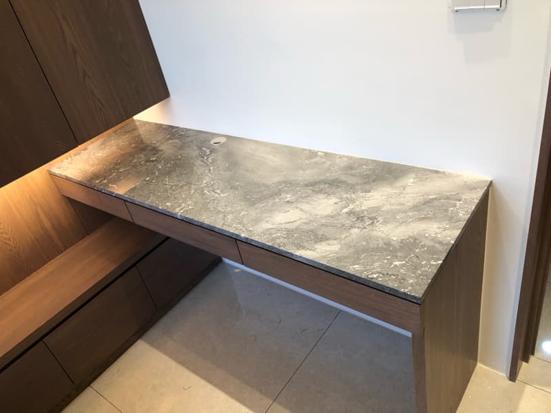 這張照片是一張灰白色大理石紋路的桌面，搭配木質櫃體，看起來非常高檔。