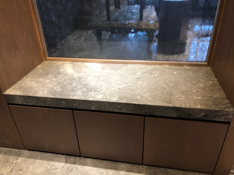 這張照片是一張灰色大理石台面的照片，台面下方有三個木頭抽屜。