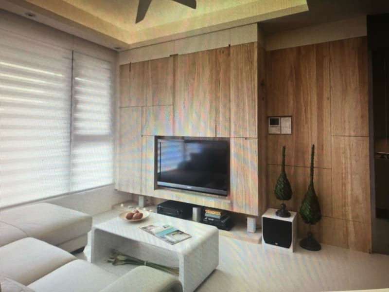 這張照片是一個簡約的客廳，牆壁上裝飾着木紋的牆板，非常具有現代感，中間有一個白色的電視櫃，擺放着一個大電視，兩側各放着一個盆栽，顯得更加自然。