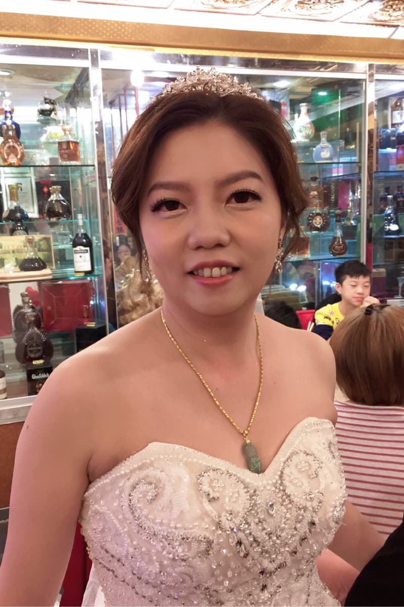 這張「婚禮」的照片是一個新娘穿著白色婚紗，戴著皇冠和項鍊，面帶微笑。