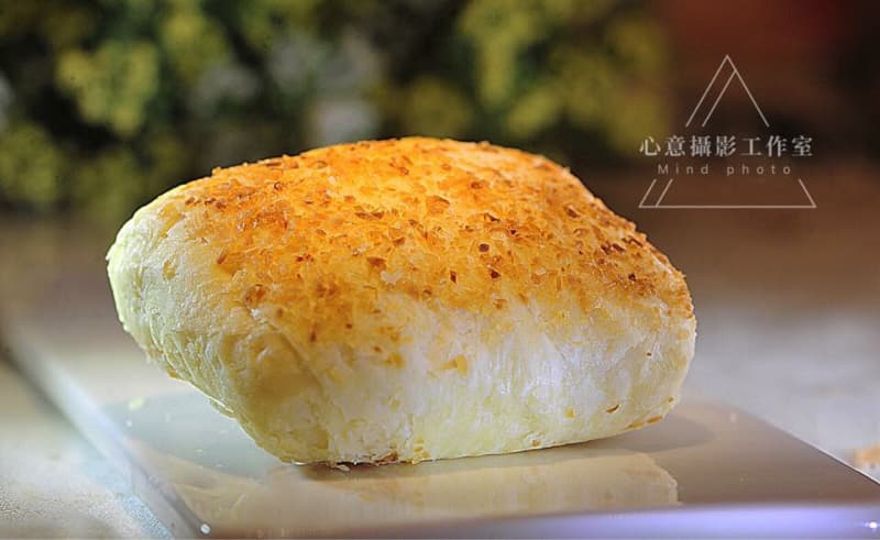 這張「椰香麵包」的照片是一塊金黃色的麵包，上面灑滿了椰絲，看起來十分美味。