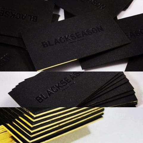 這張照片是一疊黑色名片,上面印著金色邊框的 “BLACKSEASON” 字樣。