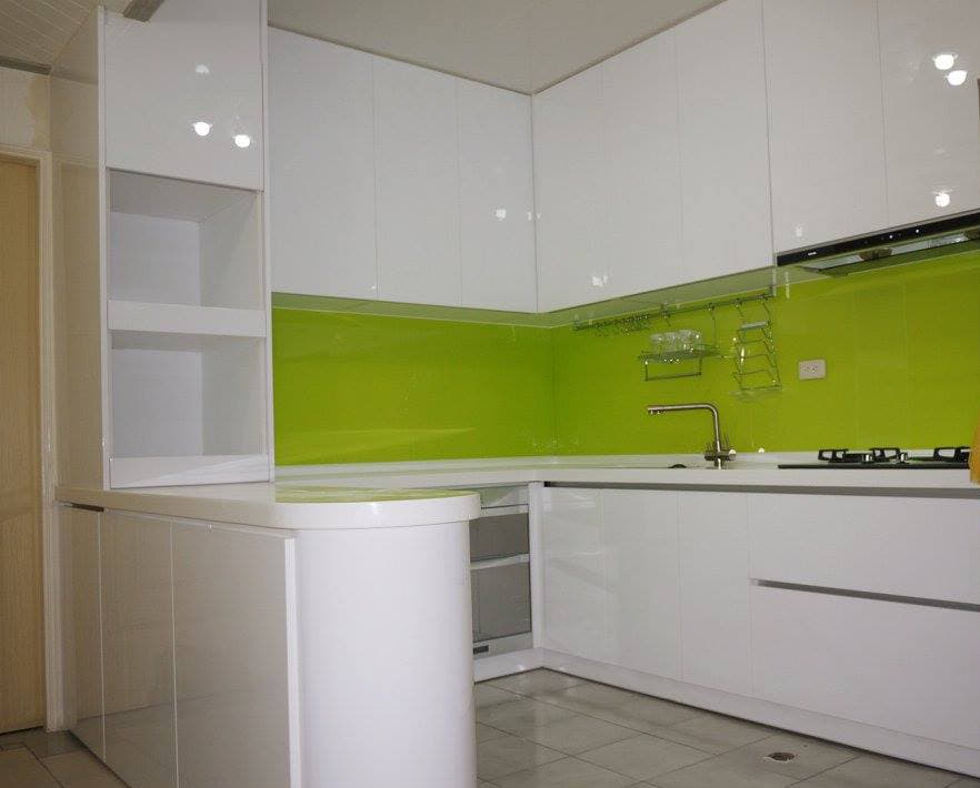 這張照片是一間現代化的廚房,廚房的牆壁是亮綠色的,搭配白色的櫥櫃和流理台,設計簡潔大方,給人乾淨明亮的感覺。