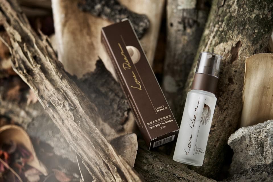 這張照片是一瓶化妝品,瓶身上有「Lome Flora」的字樣,旁邊有一個木頭背景。