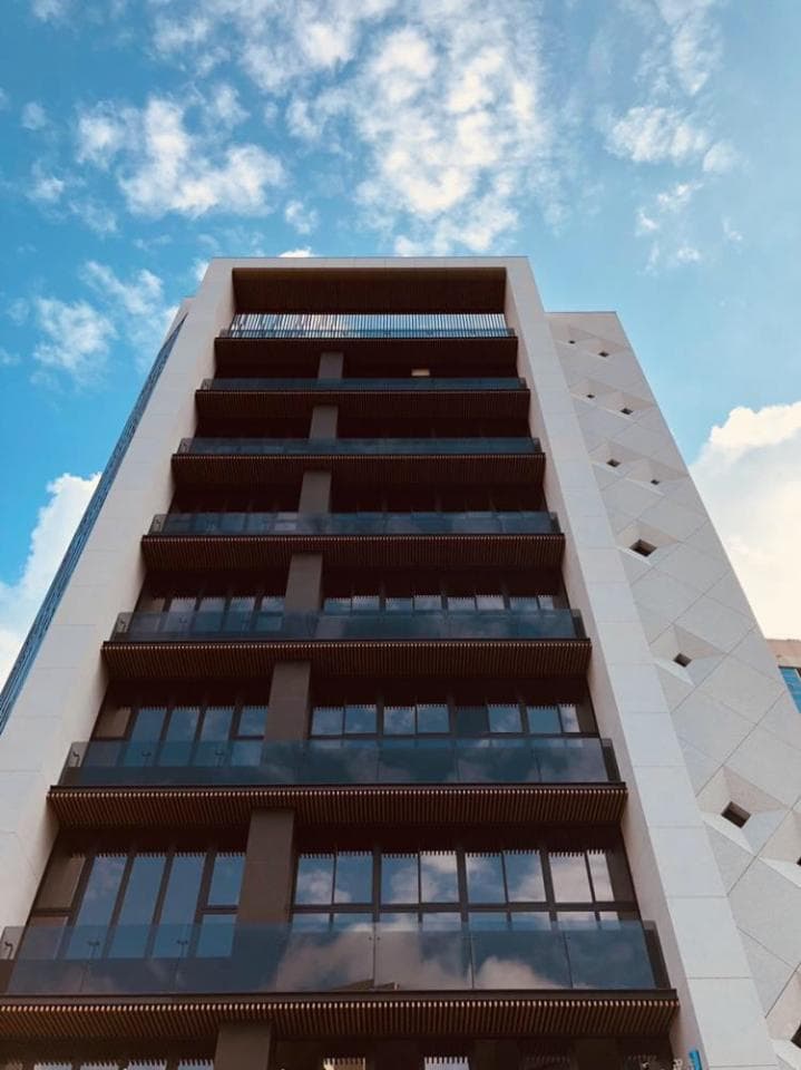 1) 照片顯示一棟現代建築,由玻璃和混凝土建成,有許多層樓,面向天空