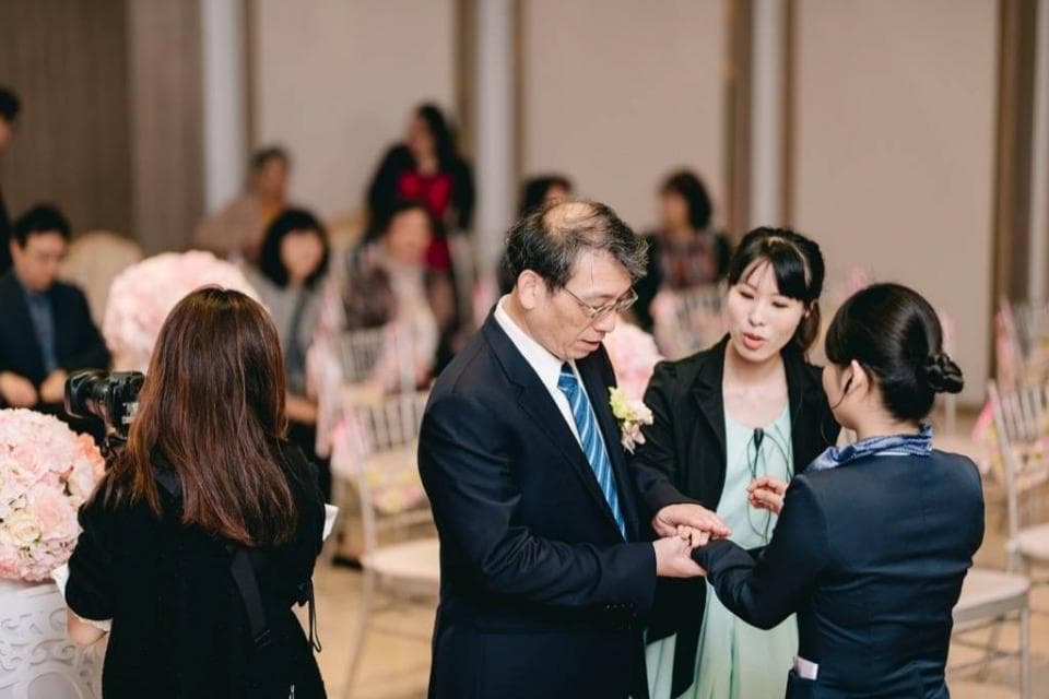 這張婚禮的照片是一個新郎和新娘在交換戒指。