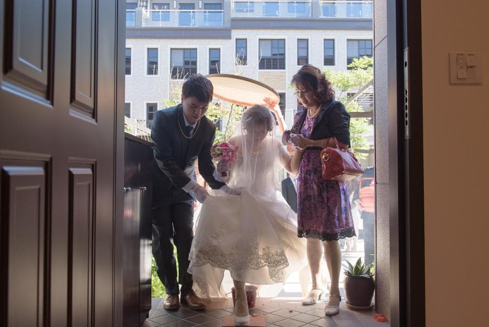 這張照片是一對新人步出教堂,新娘穿著白色婚紗,新郎則穿著黑色西裝,兩人手牽手,準備迎接人生新旅程。