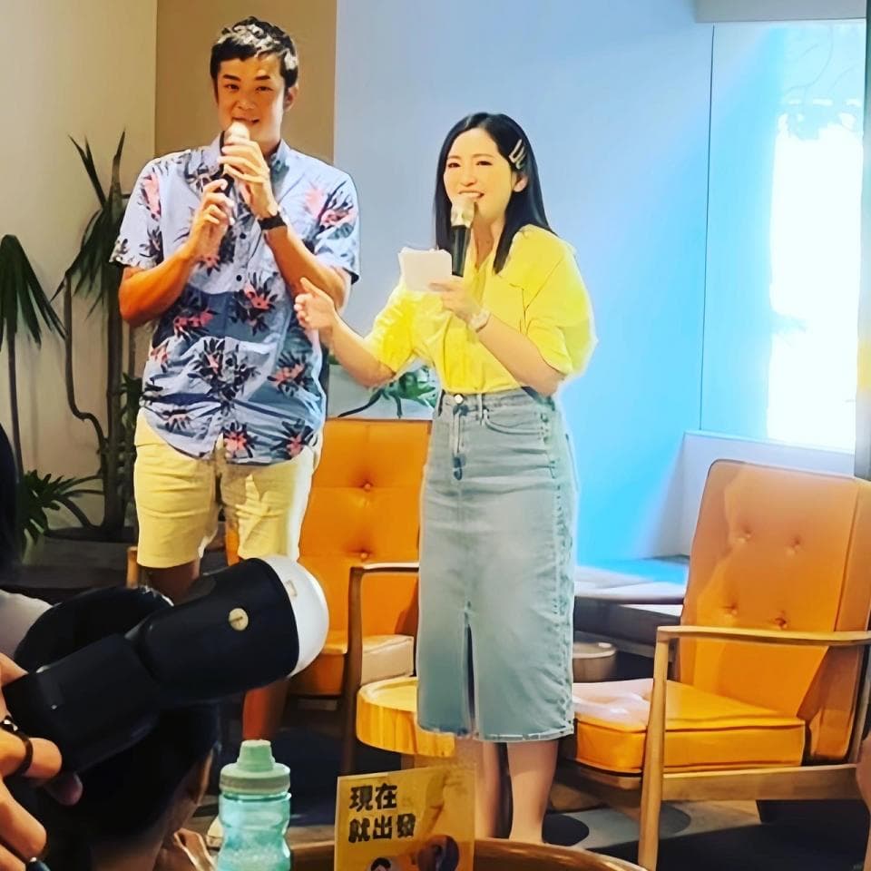 這張照片是一個年輕女子穿著紅色無肩帶連衣裙,她正看著相機微笑。